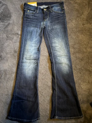 Blå bootcut jeans från Cheap Monday - Cheap monday jeans i strl 28/30.Snygga blå bootcut jeans från Weekday. Ljusa slitningar framtill. Jeansen har utsvängda ben och kontrastsömmar. Säljes för de det var för stora för mig. Original lappen är kvar på och finns kvitto.Endast testade. originalpris 399
