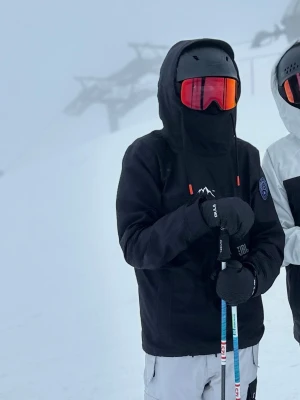Jacka och byxor från dope  - Säljer en svart vindjacka från Dope Snow med huva och hög krage. Jackan har en vit bergslogga på bröstet och en patch på ärmen. Perfekt för skidåkning med sin sportiga look och smarta detaljer som dragsko och fickor.