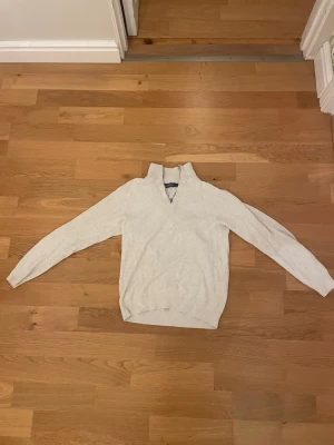 Ljusgrå stickad tröja Dressmann - Ljusgrå stickad tröja från Dressmann med halvzip och ståkrage. Tröjan har långa ärmar och ribbade muddar vid ärmslut och nederkant. Perfekt för lager-på-lager och enkel att matcha med jeans eller chinos. Storlek M Skriv vid frågor ny pris 300kr