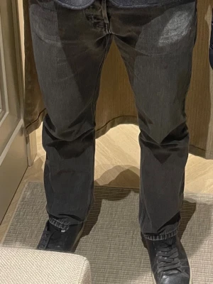 Svarta raka jeans med vintagekänsla - Säljer ett par svarta jeans med rak passform. Jeansen har en snygg tvättad look och är tillverkade i denim. 