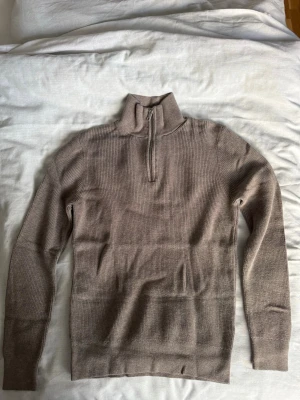 Beige stickad halvzip från H&M - Säljer en beige stickad tröja från H&M med halvzip och hög krage. Tröjan har ribbstickad struktur och långa ärmar. Storlek (S) skriv via dm vid funderingar 💬