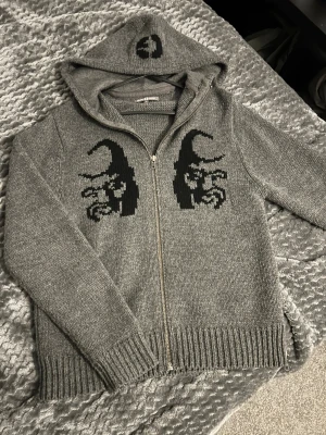 Mörkgrå stickad tröja Guru Corp - Snygg mörkgrå stickad tröja från Guru Corp i storlek M. Tröjan har grovstickad struktur och rund halsringning. Perfekt för dig som gillar en stilren och enkel look med lite edge.