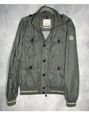 Grå vindjacka från Moncler - Snygg grå vindjacka från Moncler| nypris runt 12k| sällsynt o tillverkas ej mer| storlek L men sitter som M| mycket bra skick| äkta såklart|hör av dig vid funderingar!