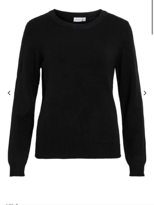 Svart stickad tröja från Vila - En klassisk svart stickad tröja från Vila med rund halsringning och långa ärmar. Tröjan har ribbade muddar vid ärmslut och nederkant. Perfekt basplagg i mjukt material som passar till allt. Köparen står för frakten