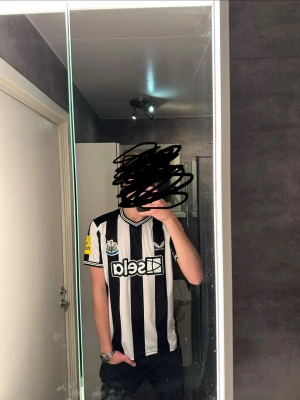 New Castle fotbollströja  - Säljer denna för de fel lag men för dig som hejar på New castle, köp. Den är i bra skick och endast lite lite sliten som kan ses på bilderna om man kollar noga. Skriv vid frågor och kolla gärna in min profil för fler feta plagg!