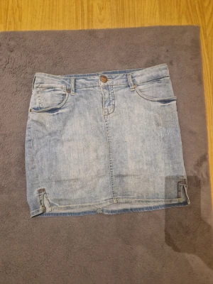 Jeans kjol - En blå jeans kjol, perfekt till sommaren. Har en prick på baksidan(se bild). Storlek W 30