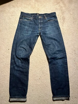 Selvedge jeans från A.P.C. - Snygga mörkblå selvedge jeans från A.P.C.                   Det är i bra skick och har lite snygga fades.     Benöppningarna är 18, längden 104, midjan 43