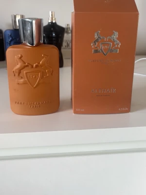 Parfums de Marly Althaïr EdP 125ml - Lyxig parfym från Parfums de Marly i modellen Althaïr. Flaskan är matt brun med silverfärgad kork och har ett elegant reliefmönster med två hästar och en sköld. Kommer i matchande brun kartong med silverdetaljer. Innehåller 125 ml Eau de Parfum.