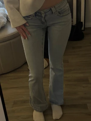 Ljusblå bootcut jeans - Säljer ett par ljusblå bootcut jeans från Gina tricot med låg midja. Knappt använda så mycket bra skick!❣️