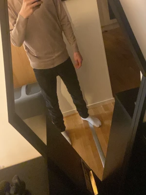 Beige stickad tröja från Smog - Snygg beige stickad tröja från Selected Homme med rund halsringning och ribbade muddar vid ärmslut och nederkant. Perfekt basplagg i mjukt material som passar till det mesta. Enkel och stilren design. Storleken står XS men den passar S också