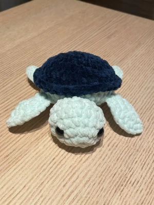 Virkad sköldpadda - Supergullig handvirkad mjukissköldpadda i ljusblått och mörkblått garn. Sköldpaddan har stora svarta ögon och mjuk, fluffig textur. Perfekt som dekoration eller gosedjur till någon som gillar söta djur och handgjorda saker. Virkad med kärlek