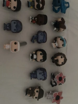 Samling Funko Pop-figurer Stranger Things - Säljer en samling med flera Funko Pop-minifigurer inspirerade av Stranger Things. Figurerna är färgglada och tillverkade i plast, med olika karaktärer och monster från serien. Perfekt för dig som gillar samlarprylar och popkultur!