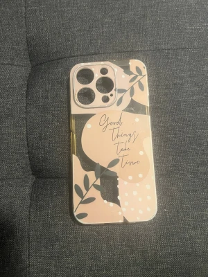 Beige mobilskal med grafiskt mönster - Snyggt mobilskal i beige och svart med grafiskt mönster, blad och texten 'Good things take time' på baksidan. Skalets material är genomskinlig plast och det har förstärkta kanter för extra skydd. Passar till mobil med tre kameralinser.
