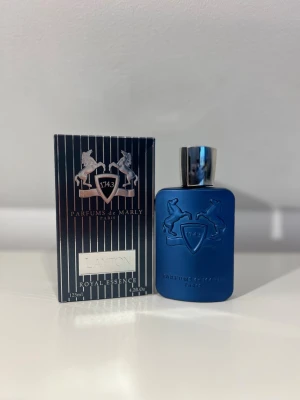 Parfums de Marly Layton EdP 125ml - Lyxig parfym från Parfums de Marly, modellen Layton. Flaskan är matt mörkblå med silverfärgat lock och har ett elegant reliefmönster med två hästar och en sköld. Kommer i originalförpackning med svart och silverrandigt mönster. Innehåll: 125 ml Eau de Parfum.