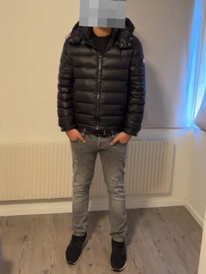 Bvaldi Dunjacka  - Säljer en svart dunjacka från Bvaldi med quiltad design och hög krage. Jackan har dragkedja framtill och en snygg logotyp på bröstet. Perfekt för kalla vinterdagar och håller dig varm med sitt tjocka material.