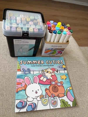 Summer Cuties målarbok - Säljer en färgglad målarbok med titeln 'Summer Cuties' fylld med söta djurmotiv och somriga illustrationer. Perfekt för dig som gillar att färglägga och vill ha något gulligt att pyssla med. Boken har mjukt omslag och många sidor med olika motiv. Även alkoholmarkers ifrån panduro som är sparsamt använda