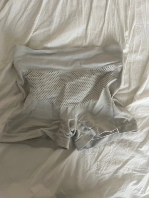 Vita seamless shapewear shorts - Vita seamless shapewear shorts med hög midja och ribbade detaljer. Shortsen har ventilerande meshpaneler framtill och scrunch-effekt bak för extra form. Tillverkade i stretchigt syntetmaterial som sitter tight och bekvämt.