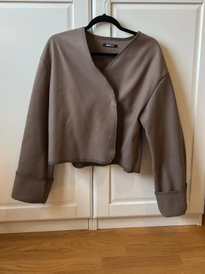 Brun cardiganjacka från Gina Tricot - Säljer en brun cardiganjacka från Gina Tricot med boxig passform och breda ärmar. Jackan har dekorativa sömmar längs kanterna🙌🏼🙌🏼