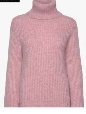 Rosa stickad polotröja från Soyaconcept - Mysig rosa stickad polotröja med ribbad struktur och långa ärmar. Tröjan har en hög polokrage och är tillverkad i ett mjukt, fluffigt material som passar perfekt för kyliga dagar. Pris kan diskuteras!💞