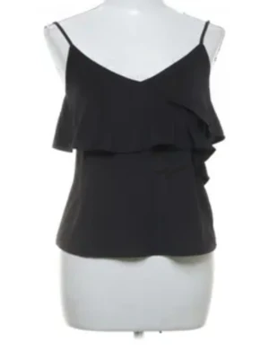 Svart volangtopp❣️ - Snygg svart linnetopp från H&M med tunna axelband och volangdetaljer framtill. Perfekt för dig som gillar en enkel men ändå trendig look. Tillverkad i mjukt material som känns skönt mot huden. Pris går att diskutera!!🫰🏻