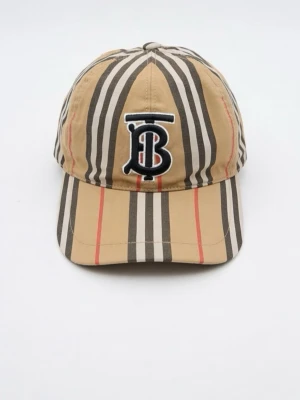 Beige randig keps från Burberry - Säljer en snygg keps från Burberry med klassiskt beige, svart, vit och röd randigt mönster. Kepsen har en böjd skärm och ett broderat TB-monogram framtill. Tillverkad i ett lätt och bekvämt material som passar perfekt till streetwear-looken.