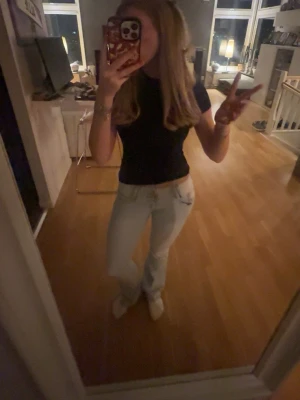 Lowwaist bootcut jeans - Lågmidjade ljusblåa bootcut jeans med unik knapp design! Byxorna har tyvärr fått än liten fläck på ena låret (se sista bild), dock ej testat få bort med fläckrengöring eller liknande. Mått finns på bilderna, skulle de finnas ytterligare frågor är det bara att skriva!😊(Jeans materialet är ganska mjukt och stretchigt)