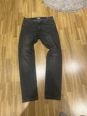 Svarta slim fit jeans - Säljer ett par svarta slim fit jeans med klassisk femficksdesign och dragkedjegylf. Jeansen har en lätt tvättad look och raka ben. Perfekta till en avslappnad grisch-stil.