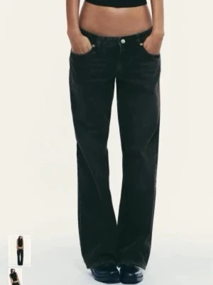 Svarta baggy jeans med raka ben - Säljer ett par svarta baggy jeans med raka ben och klassisk femficksdesign. Jeansen har låg midja och avslappnad passform, perfekta för en chill och trendig look. Materialet är denim och de har knapp- och dragkedjegylf.