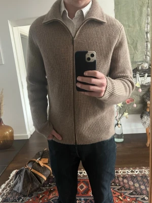 Beige stickad ziptröja från Davida - Säljer en beige stickad ziptröja från Davida. Hel dragkedja framtill och är ribbstickad i ett mjukt 100% kashmire material. Perfekt för lager på lager och ger en clean look till jeans eller chinos. Nypris ungefär 4000. Skick: 9,5/10