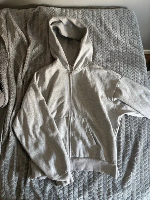 Ljusgrå scuba zip hoodie från Weekday - Ljusgrå hoodie med dragkedja från Weekday. Klassisk modell med huva och känguruficka framtill. Tillverkad i mjukt sweatshirtmaterial, perfekt för en chill och avslappnad stil.