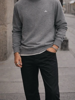 J.Lindeberg grå crewneck – clean minimalist - Beskrivning: Stilren grå crewneck från J.Lindeberg med diskret logga på bröstet. Perfekt för en clean och minimalistisk look – funkar lika bra till jeans som cargos eller över en skjorta.  Ett riktigt bra basplagg som alltid funkar i garderoben. ⸻ Passform: Regular fit – avslappnad men fortfarande stilren