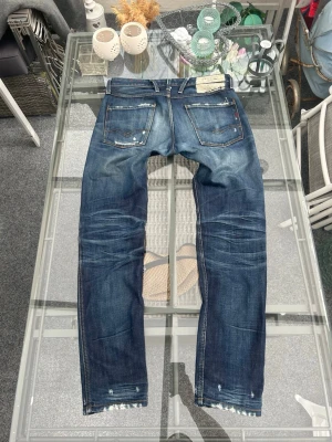 Replay Anbass jeans W32 L32 – slim fit, vintage wash - Säljer ett par sjukt clean Replay Anbass jeans i snygg blå vintage wash 👖✨  Storlek W32 L32 Modell Anbass – en av Replays mest populära fits Slim fit med tapered ben och riktigt snygga fades/slitningar  Premium denim med naturligt slitage som ger den perfekta vintage streetwear looken. Funkar till sneakers, loafers, hoodie eller stickat. Riktigt bra everyday jeans med dyr känsla 🔥  Bra skick och sitter riktigt bra på kroppen. 