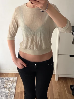Ljusbeige glittrig topp  - ljusbeige glittrig topp med trekvartsärm 💗💗. Toppen är något transparent och har en croppad passform som sitter snyggt i midjan. Storlek M men sitter fint på de som har XS/S i storlek 🌷