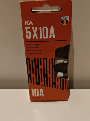 ICA smältproppar 5x10A - Förpackning med fem vita smältproppar från ICA, 10A, i originalkartong. Propparna är avsedda för elinstallationer och har märkning för 500V. Förpackningen är orange med tydlig text och fönster som visar propparna. Ibs : Det är bara fyra som är nya och ovända trots att du får fem.