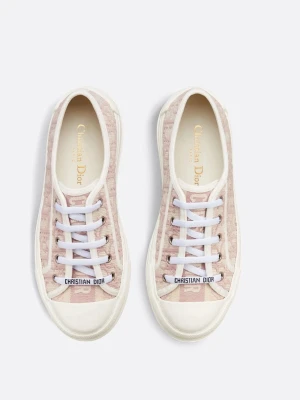 Dior rosa låga sneakers - Snygga låga sneakers från Christian Dior i ljusrosa och vitt med tydligt Dior-mönster på canvasmaterial. Skorna har vita snören och detaljer med logotypen på snörningen. Klassisk rund tå och vit sula ger en clean look som sticker ut.
