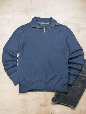 Marinblå stickad tröja Jack & Jones - Snygg marinblå stickad tröja från Jack & Jones med halv dragkedja och hög krage. Tröjan har ribbade muddar vid ärmslut och nederkant, perfekt för lager på lager. Enkel och stilren design som passar till det mesta.