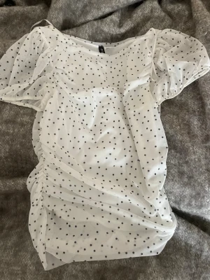  topp med svarta prickar - Säljer en söt vit mesh topp med svarta prickar och korta ärmar. Sjukt snygg till våren och sommaren med snygga jeans eller en fin kjol💝🥰pris kan diskuteras 