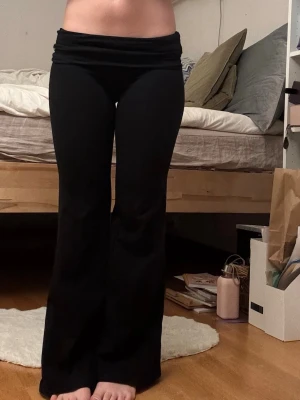 Svarta bootcut leggings från SHEIN - Säljer ett par svarta yogabyxor från SHEIN i storlek XS. De har bootcut-modell med utsvängda ben och bred linning i midjan. Perfekta för en chill och trendig look. Materialet är stretchigt för extra komfort.