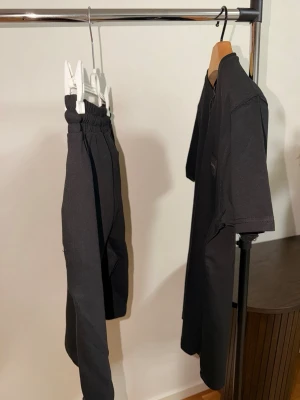 Svart loungewear-set från Boss - Snyggt svart loungewear-set från Boss med t-shirt och både långa byxor och shorts. Alla delar har avslappnad passform och mjukt material, perfekt för chill dagar hemma. Byxorna och shortsen har resår i midjan och dragsko för extra komfort. Boss-logga syns diskret på shortsen. Storlek M passar S