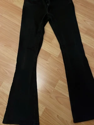 Svarta bootcut jeans från Perfect Jeans - Säljer ett par svarta bootcut jeans från Perfect Jeans i storlek 36. Jeansen har utsvängda ben och klassisk femficksdesign. Perfekta för dig som gillar en retroinspirerad look med modern twist.