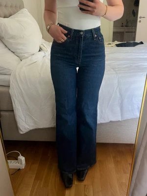 Levi's mörkblå jeans - Mörkblå bootcut jeans från Levi's med hög midja. Använt fåtal gånger och i jättebra skick. De är i modellen ”ribcage bell” från Levi’s. Storlek : W25 samt L32, vilket motsvarar XS/34 Nypris : 1349kr