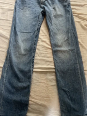 True Religion Ricky Relaxed Straight jeans - Snygga ljusblå jeans från True Religion, modell Ricky Relaxed Straight. Jeansen har rak passform och klassisk femficksdesign. Tillverkade i denim med en lätt tvättad look och subtila slitningar för en avslappnad stil.
