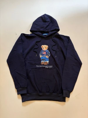 Ralph Lauren hoodie L - Marinblå Ralph Lauren polo bear hoodie // 10/10 skick aldrig använd // storlek L // längd 66cm axelbredd 52cm armlängd 60cm // skriv vid minsta fråga eller fundering🤝