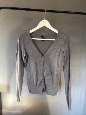 Grå kofta från H&M med v-ringning - En stilren grå kofta från H&M med v-ringning och knäppning framtill 💞