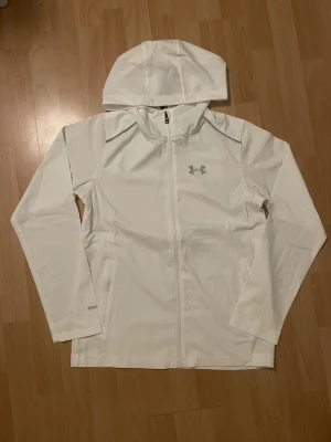 Under Armour Jacka - Vit Under Armour jacka/vindjacka helt ny i storlek M, men passar som S/XS. Kommer med ddustbag och tags. Mått finns. Prisförslag eller frågor är välkomna! 🙏💬