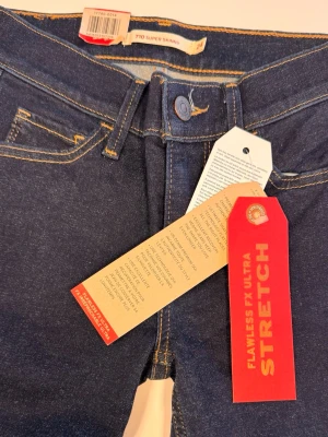 Levi's 710 Super Skinny jeans blå - Mörkblå super skinny jeans från Levi's, modell 710 med klassiska gula sömmar och femficksdesign. Jeansen har ultra stretch för perfekt passform och är tillverkade i stretchigt denimtyg. Perfekta för dig som gillar en tight siluett.
