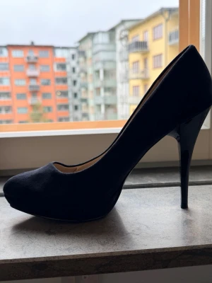 Svarta pumps från Zara med klack - Stilrena svarta pumps från Zara med spetsig tå och hög smal klack. Skorna är i mockaimitation och har en klassisk siluett som ger en elegant look. Perfekta för dig som gillar en tidlös och trendig stil.