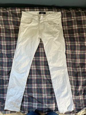 Vita slim fit jeans från Replay - Snygga vita jeans från Replay i slim fit-modell med klassisk femficksdesign. Jeansen har raka ben och är tillverkade i ett stretchigt bomullsmaterial som ger en skön passform. Perfekta för dig som vill sticka ut med en fräsch look.