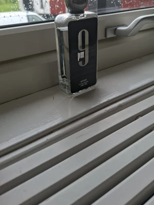Afnan 9PM Eau de Parfum 100ml - En helt ny Afnan 9PM är en parfym i en stilren, rektangulär glasflaska med svart etikett och silverdetaljer. Flaskan rymmer 100 ml och har en modern design som passar perfekt på parfymhyllan. Doften är unisex och passar dig som gillar eleganta och fräscha parfymer.