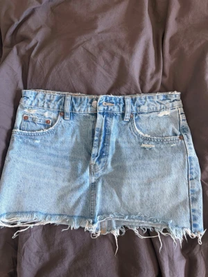 Ljusblå jeanskjol från Zara - Jeanskjol med slitningar. Superfin kjol till sommaren.
